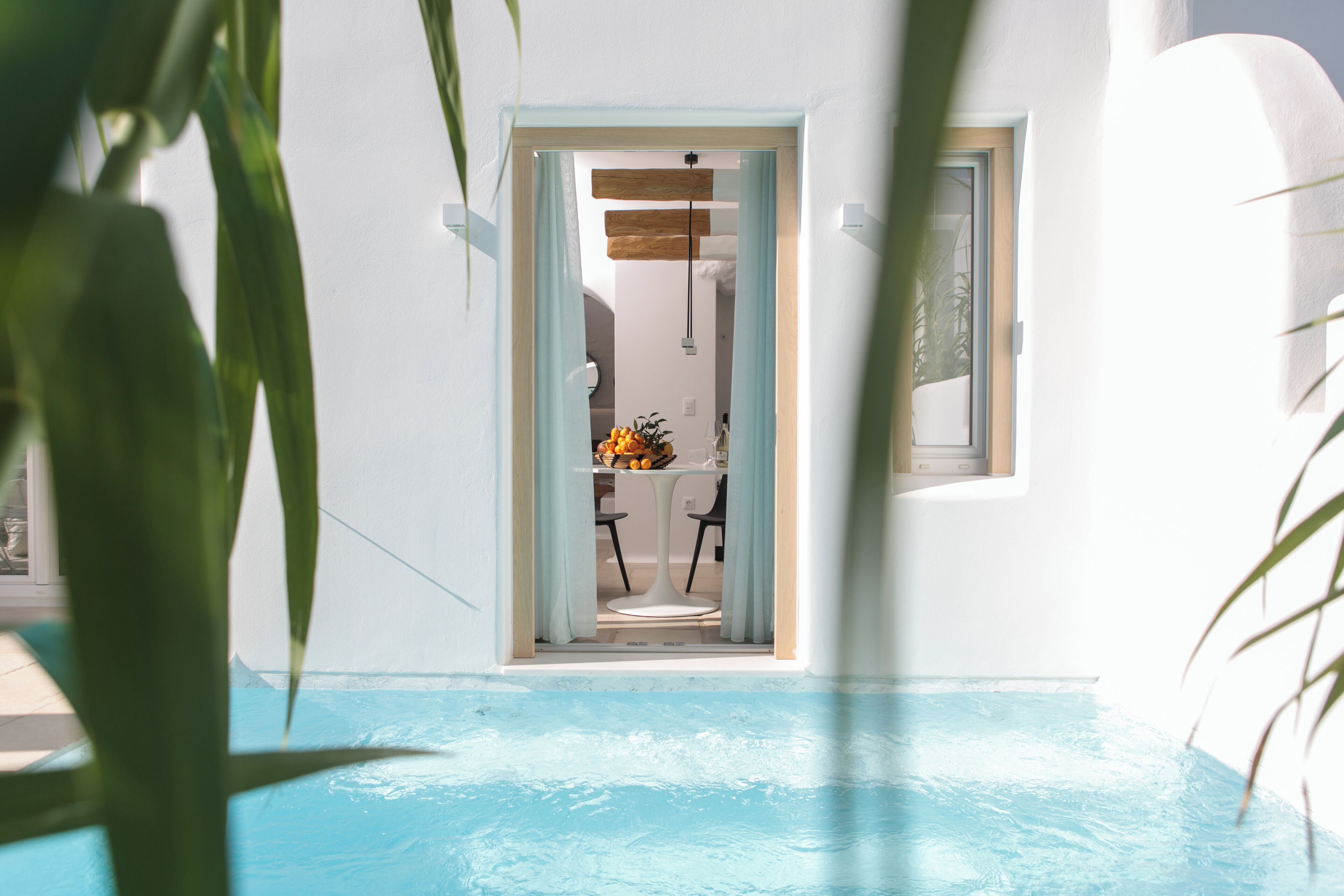 Uma área de piscina com vista para uma sala de jantar e uma porta que dá para outro quarto.