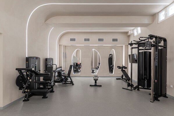 A gym with exercise equipment, mirrors, and a clean, modern design.