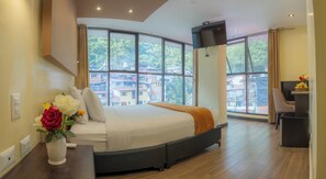 Ein modernes Hotelzimmer mit einem großen Bett, einem Schreibtisch und einem Fernseher.