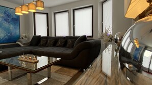 A modern living room with a dark sofa, a glass coffee table, and a large abstract painting on the wall. - NEW 5 star holiday comfort apartment (Braunlage)