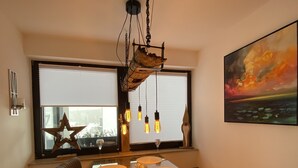 A modern dining area with a wooden table, cushioned seating, and pendant lighting. - NEW 5 star holiday comfort apartment (Braunlage)