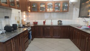 Eine Küche mit Holzschränken, einer gefliesten Spritzschutzwand und einer Arbeitsplatte aus Granit.