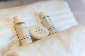 Three toiletry bottles on a white towel. - Mountsorrel House (Loughborough)