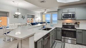 A modern kitchen with a large island, stainless steel appliances, and a view to the outside. - Fall Dates Available! Book Now! Great Location! (Panama City Beach)