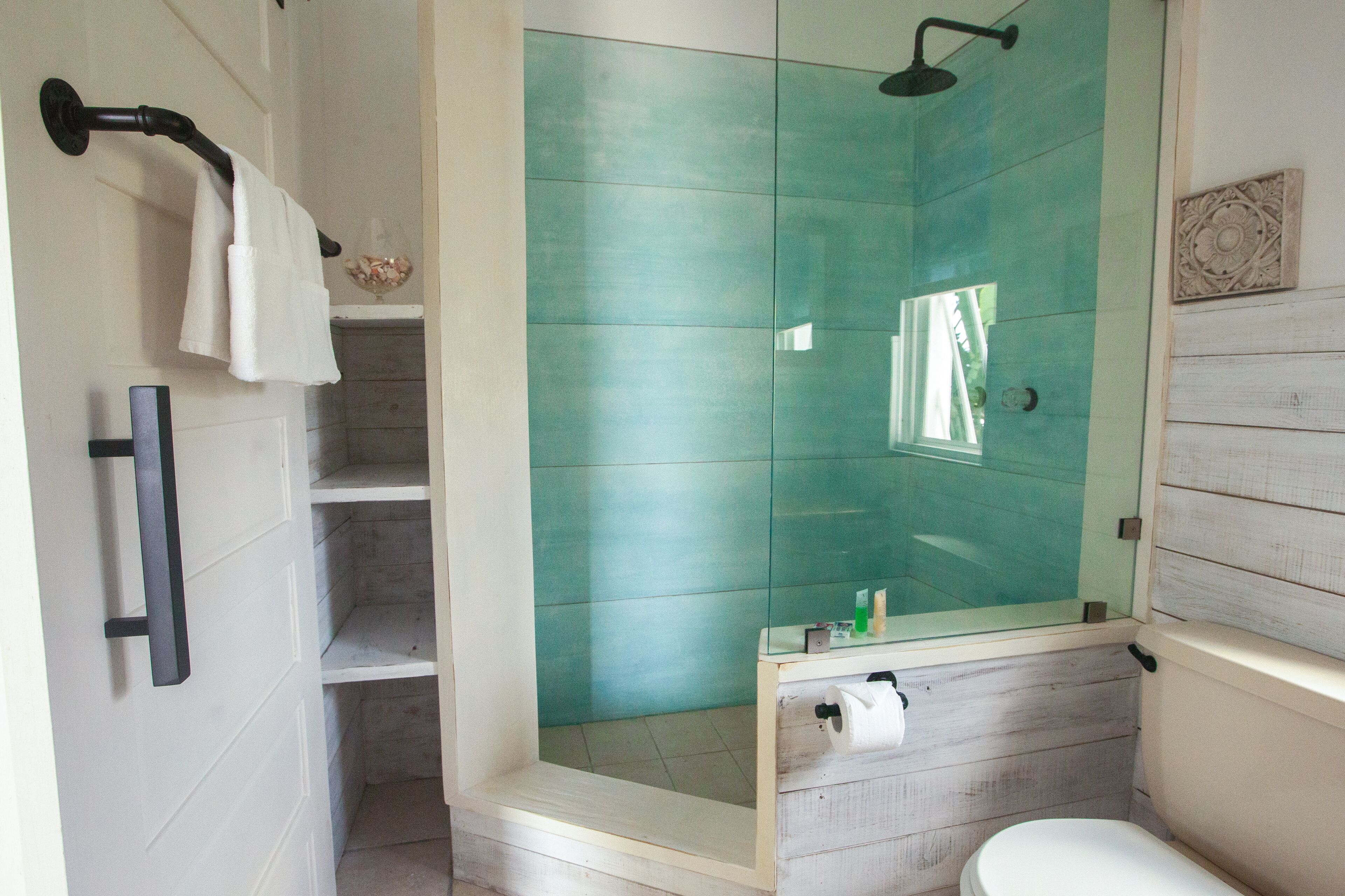 Un baño con cabina de ducha de vidrio, inodoro y lavamanos.