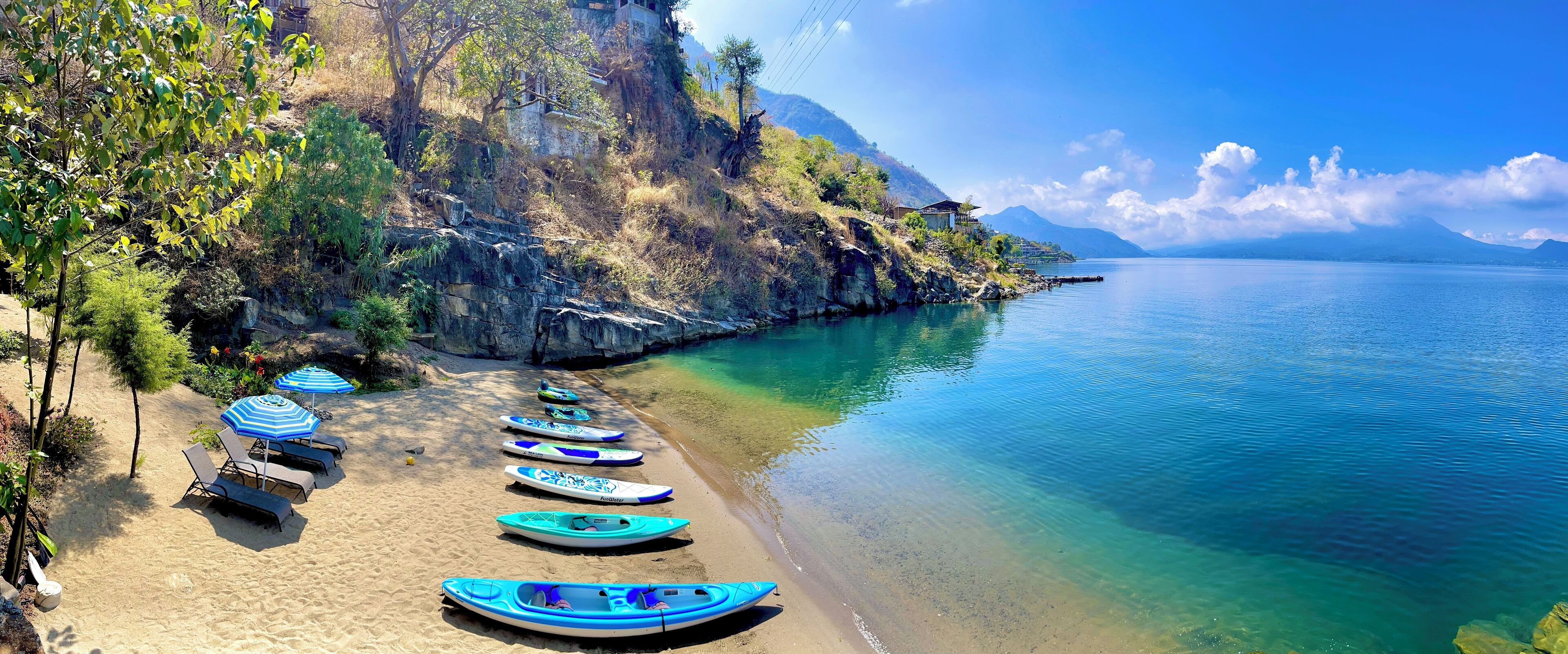 Ranta lähistöllä, aurinkotuoleja, rantapyyhkeitä