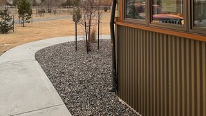 A modern building with large windows, a concrete pathway, and a gravel area. - Modern Dog Friendly Paradise Valley Home near Yellowstone NP & Chico Hot Springs (Pray)