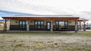 A lodge with a covered patio, stone pillars, and a view of the surrounding landscape. - Modern Dog Friendly Paradise Valley Home near Yellowstone NP & Chico Hot Springs (Pray)