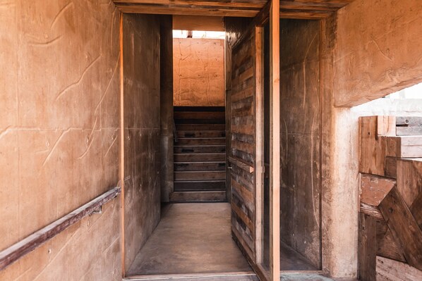 Una estrecha escalera de madera que sube a un nivel superior.