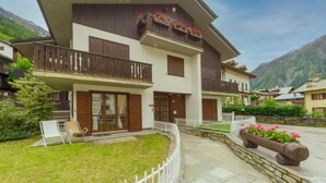 Ein mehrstöckiges Hotel mit Balkonen, einem überdachten Eingang und einem gepflasterten Weg.