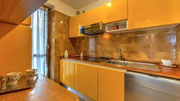 Een koelkast, een microgolfoven, kookgerei, borden en bestek