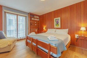 A bedroom with a bed, a wooden wardrobe, a bookshelf, a desk, and a chair. - APT CAMILLE (Courmayeur)