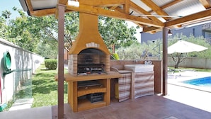 An outdoor patio with a brick oven, a sink, and a pool. - Villa with pool for 6 people (Pula)