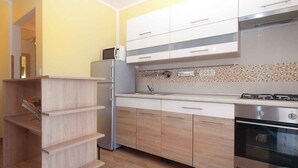 A modern kitchen with a built-in microwave, refrigerator, gas stove, and wooden cabinets. - Villa with pool for 6 people (Pula)