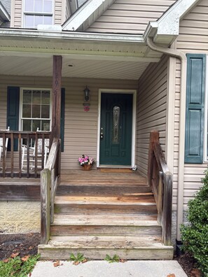 A house with a front porch, a green door, and a mailbox.