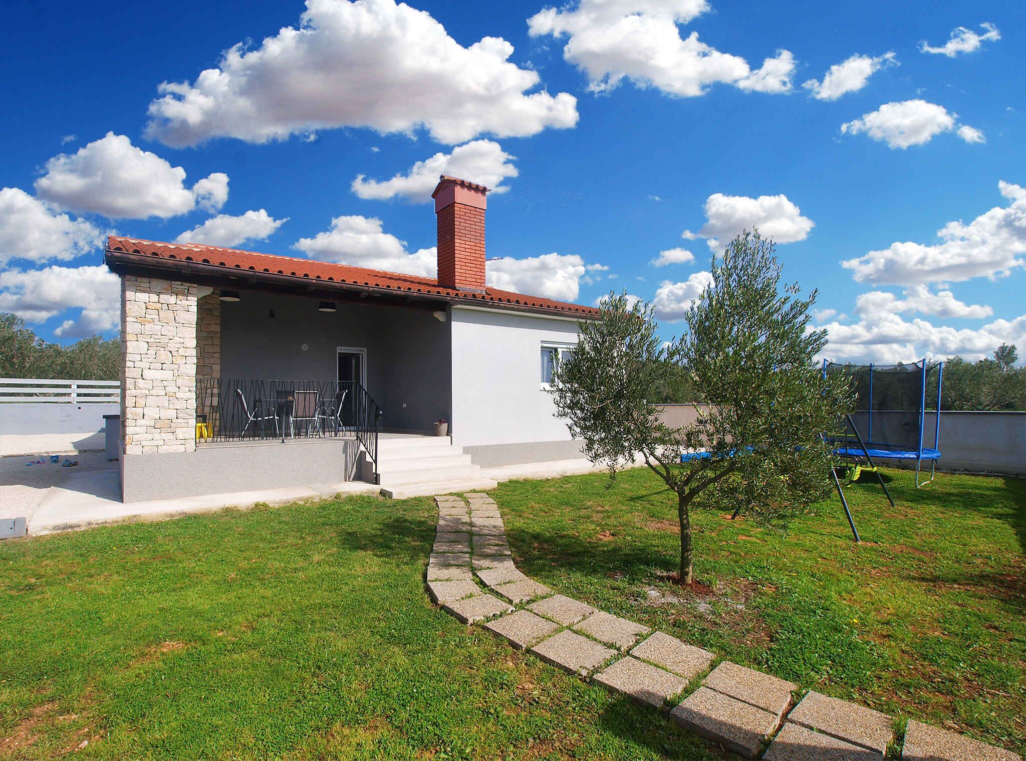 A single-story house with a stone facade and a red-tiled roof.