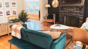 Ein Wohnzimmer mit Kamin, Fernseher und Couchtisch.