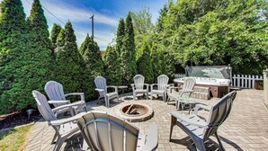 An outdoor patio with Adirondack chairs, a fire pit, and a hot tub. - Captain Cook, Hot Tub, Sleeps 9 (Lake Geneva)