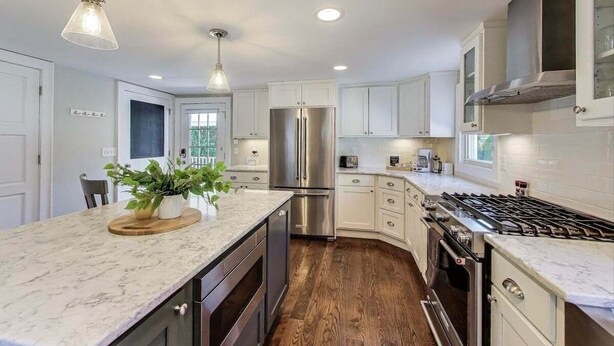 A modern kitchen with white cabinets, a stainless steel refrigerator, a gas stove, and a wooden countertop with a plant. - Captain Cook, Hot Tub, Sleeps 9 (Lake Geneva)