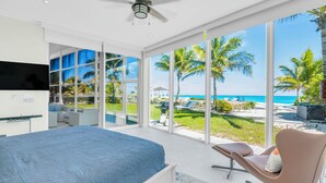 Une chambre avec un lit, une télévision et vue sur la plage.