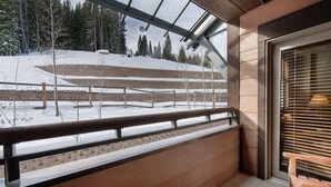 Un balcon donnant sur un paysage enneigé et des arbres.