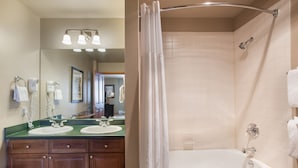 Une salle de bain avec deux lavabos, une douche et un miroir.