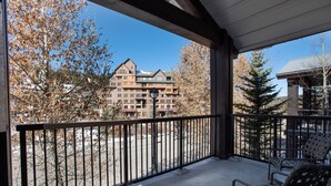 A balcony with a view of a multi-story building, a metal railing, and two wicker chairs. - Fraser Crossing/Founders Pointe, Condo | 2 Bedroom (Value-Rated Condo 4281) (Winter Park)