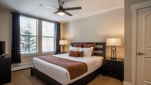 A hotel room with a large bed, two bedside tables with lamps, a ceiling fan, and a window with blinds. - Fraser Crossing/Founders Pointe, Condo | 2 Bedroom (Value-Rated Condo 4281) (Winter Park)