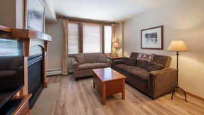 A living room with a fireplace, two sofas, a coffee table, and a floor lamp. - Zephyr Mountain Lodge, Condo | 2 bedroom Ski Slopes Balcony Views (Value Rated Condo 2411) (Winter Park)