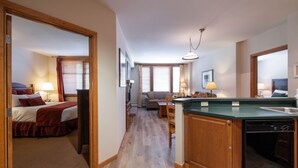 A hotel room with a bed, a desk, a dining area, and a kitchen with a dishwasher. - Zephyr Mountain Lodge, Condo | 2 bedroom Ski Slopes Balcony Views (Value Rated Condo 2411) (Winter Park)