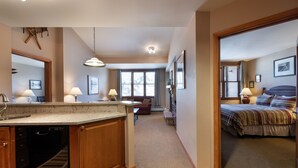 A spacious kitchen with wooden cabinets and a built-in dishwasher, a cozy living area with a sofa and a dining table, and a bedroom with a bed and a nightstand. - Zephyr Mountain Lodge, Condo , 2 bedroom (Select-Rated Condo 1604) (Winter Park)