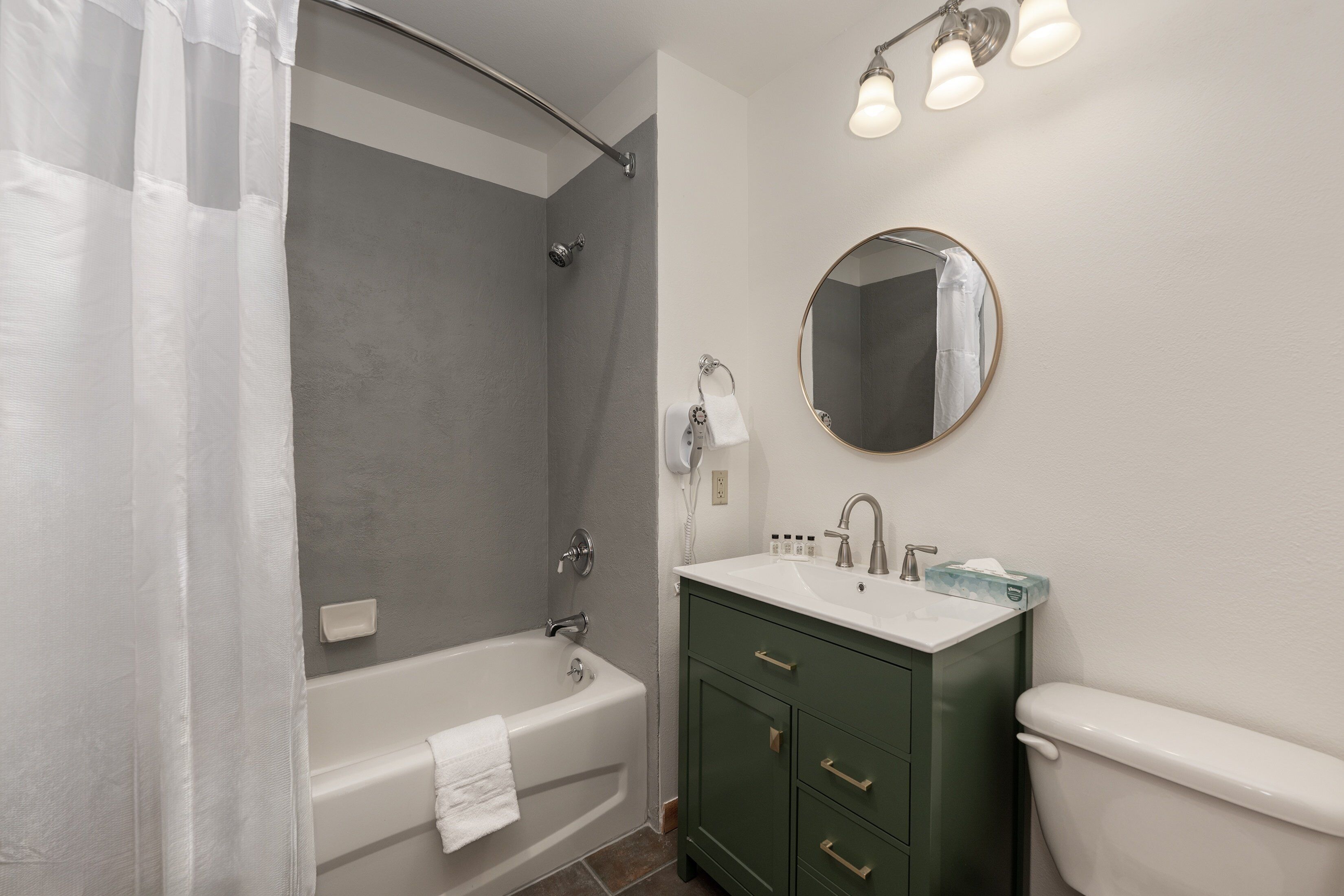 A bathroom with a bathtub, a toilet, a sink, and a shower curtain.