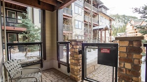 A covered outdoor area with a metal gate, a bench, and a stone wall.