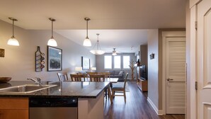 A modern kitchen with a central island, built-in dishwasher, and pendant lighting. - Fraser Crossing/Founders Pointe, Condo , 2 bedroom (Premium-Rated Condo 3506) (Winter Park)
