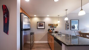 A modern kitchen with stainless steel appliances, wooden cabinets, and a granite countertop. - Fraser Crossing/Founders Pointe, Condo , 2 bedroom (Premium-Rated Condo 3506) (Winter Park)