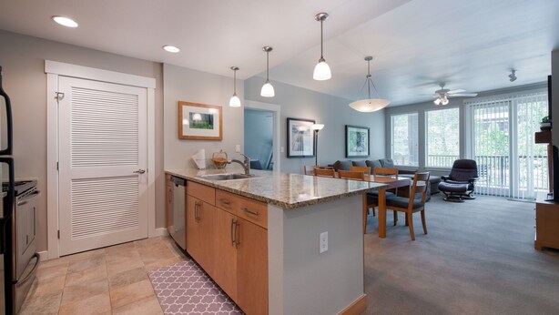 A modern kitchen with a central island, wooden cabinets, and pendant lighting. - Fraser Crossing/Founder Pointe, Townhome style Condo | Gondola Acess (Value-Rated Condo 3229) (Winter Park)