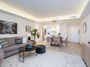 Una sala de estar moderna con un sofá, una mesa de centro y un comedor con sillas y una mesa.