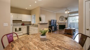 A modern kitchen with white cabinets, a dining table with a wooden top, and a potted plant. - Cozy 1-Bdrm Scottsdale Condo next to pool (Scottsdale)