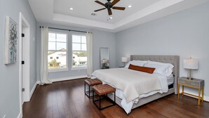 A bedroom with a large bed, a ceiling fan, a nightstand with a lamp, and a window with curtains. - New Luxury Stay mins from Downtown w/ dreamy common area (Houston)