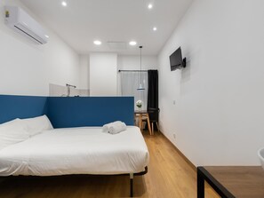 A modern hotel room with a single bed, a desk, and a television mounted on the wall. - Hotelito Boutique Valencia Estación 5 (Valencia)
