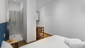Ein modernes Badezimmer mit Dusche, Waschbecken und Spiegel.