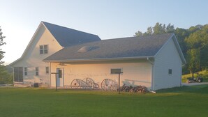 Une maison à deux étages avec un garage, une pelouse bien entretenue et un élément décoratif en métal représentant de l’eau, situé au premier plan.