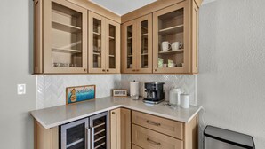 Eine Küche mit Holzausstattung, einer Kaffeestation und einem Schild mit der Aufschrift 'Welcome to our Beach House'.