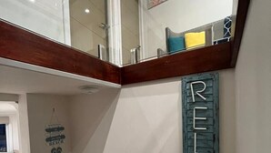 A modern interior with a wooden ceiling, a glass door leading to a balcony, and a wall-mounted sign that reads "RELAX". - Your Perfect Retreat with Unlimited WiFi, Netflix,Steps Away from Beach & Shops  (Rosebud)