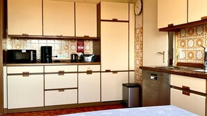 Eine kleine Küche mit Mikrowelle, Kaffeemaschine, Toaster und Geschirrspüler.