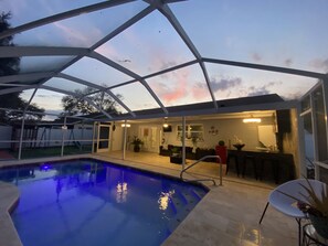 A pool area with a glass enclosure, a bar, and a dining area. - Modern Heater pool house tampa. Close to the park and zoo (Tampa)