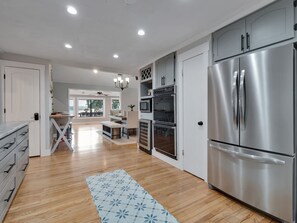 A modern kitchen with stainless steel appliances, wooden flooring, and a dining area with a view. - Talquin Time: Lakefront - Dock - Pool Table (Quincy)