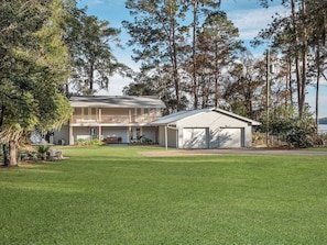 A two-story house with a front porch, a garage, and a well-maintained lawn. - Talquin Time: Lakefront - Dock - Pool Table (Quincy)