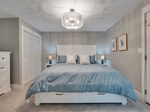 A bedroom with a bed, bedside lamps, a chandelier, a wardrobe, and a door. - Talquin Time: Lakefront - Dock - Pool Table (Quincy)