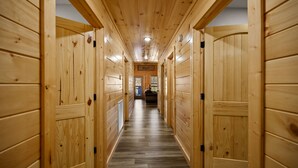 A wooden hallway with doors on both sides, leading to a room with a window and a sign that reads "Relaxed".